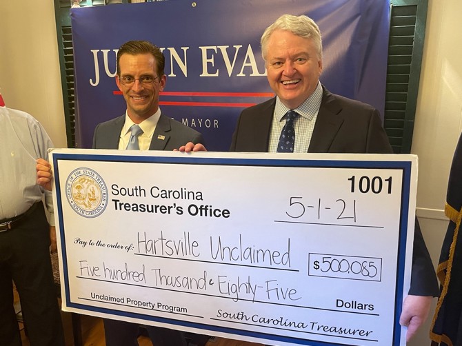 Hartsville native and mayoral candidate Justin Evans is joined by State Treasurer Curtis Loftis Tuesday to help return missing funds to two local Hartsville citizens.